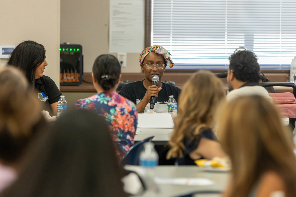 woman speaking to a large group of people.