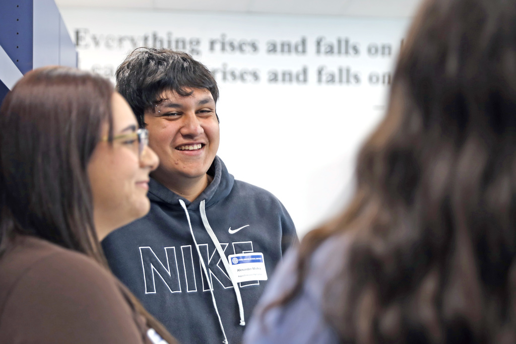 Student laughing while talking with two other students