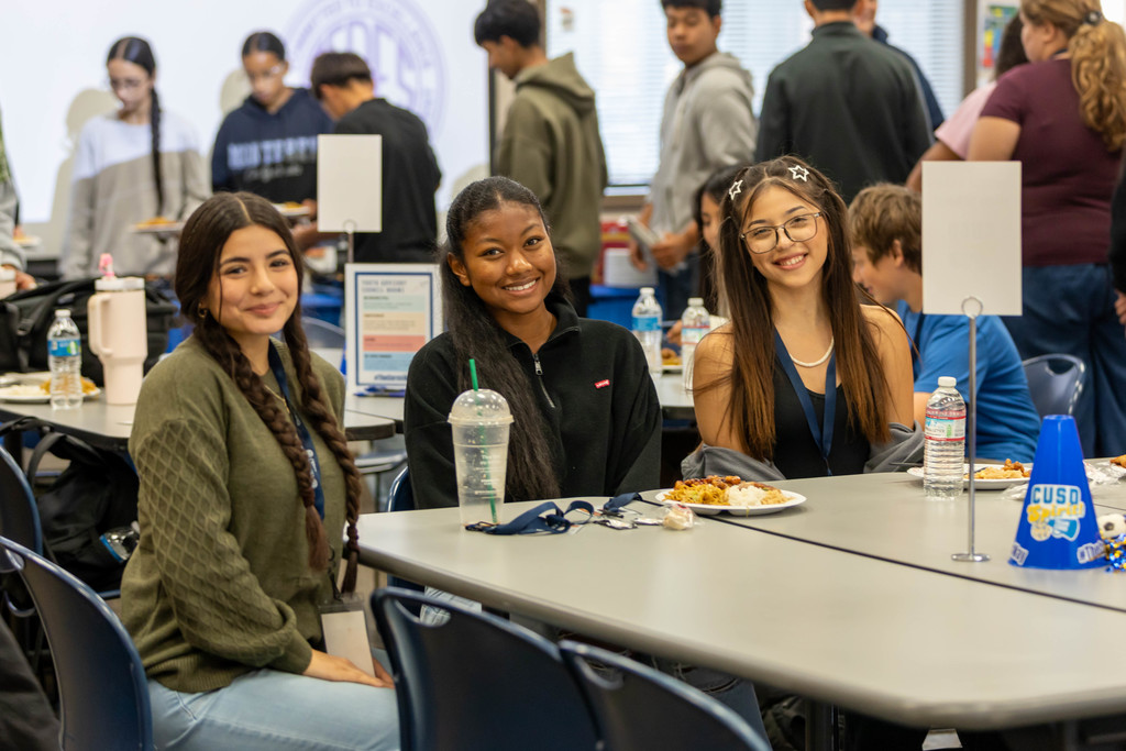 students smiling at a table