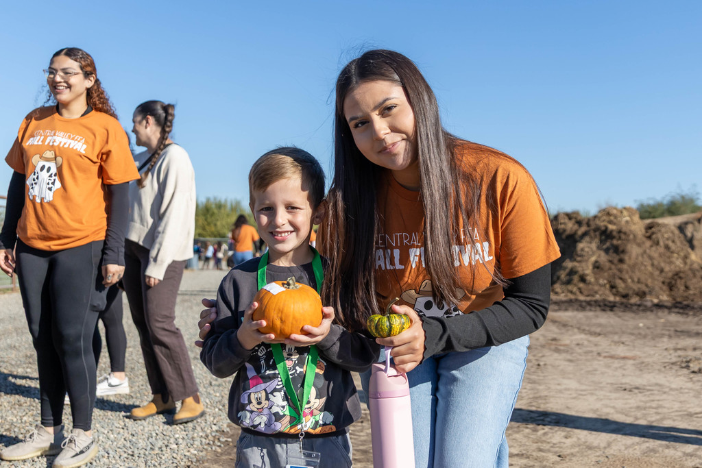 students holding pumpkins
