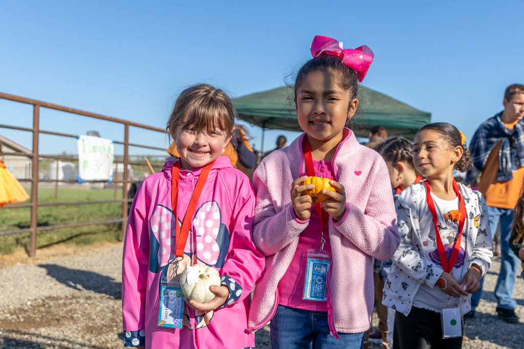 students holding pumpkins