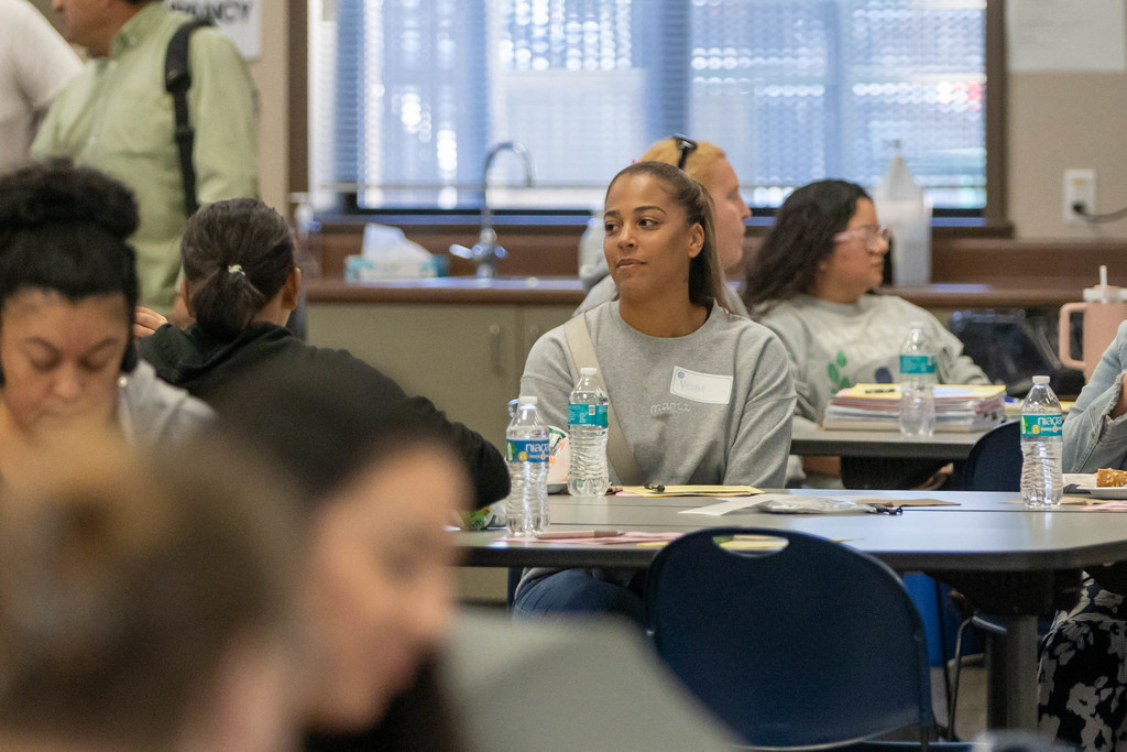 Woman talking to a group of people at a table