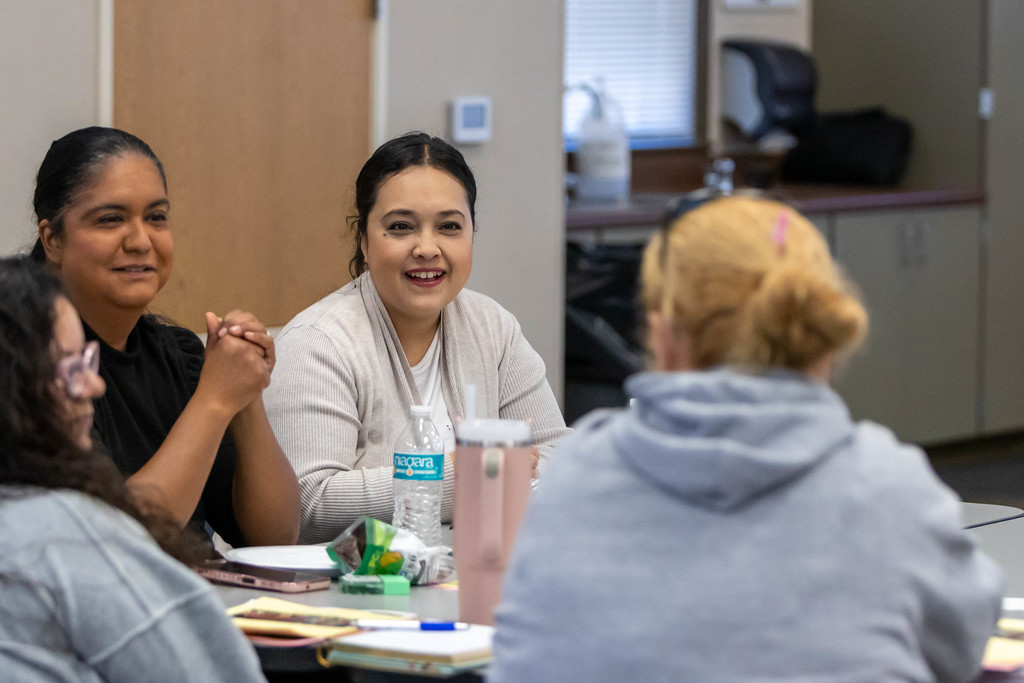 Woman talking to a group of people at a table