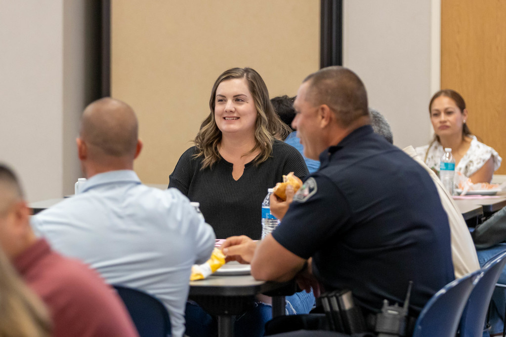 Woman talking to a group of people at a table