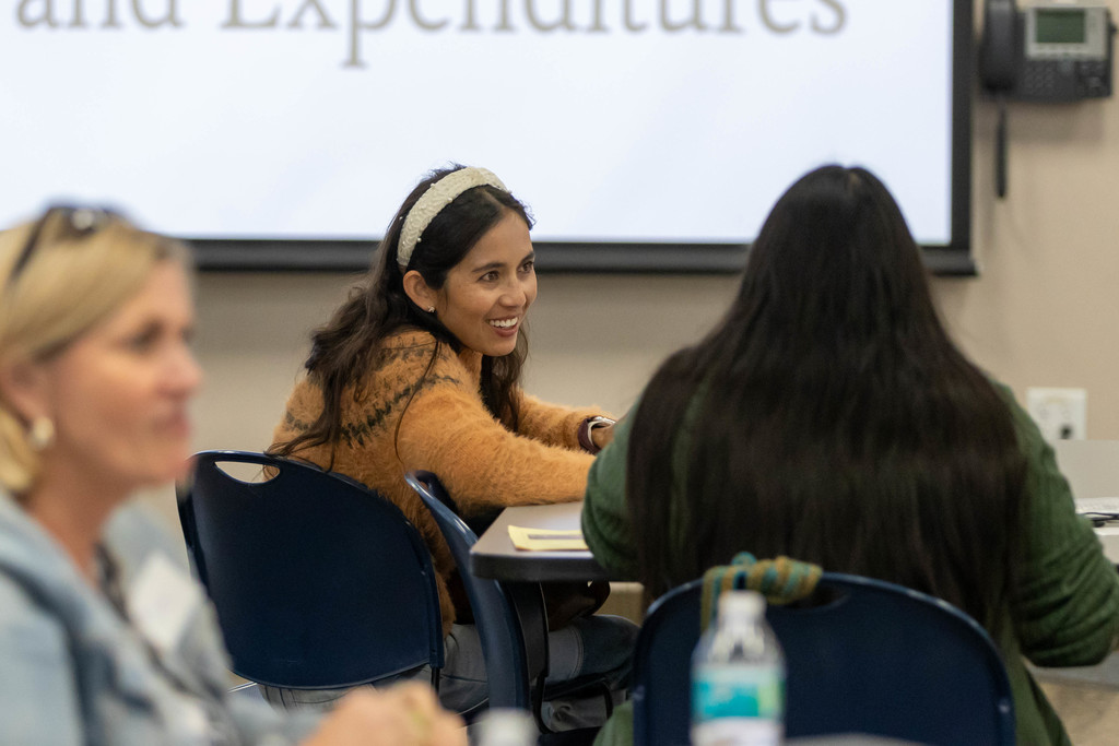 Woman talking to a group of people at a table
