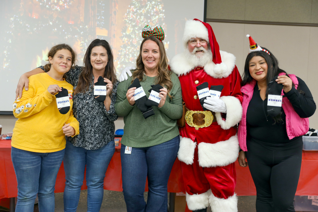 Santa and four helpers holding Bombas socks
