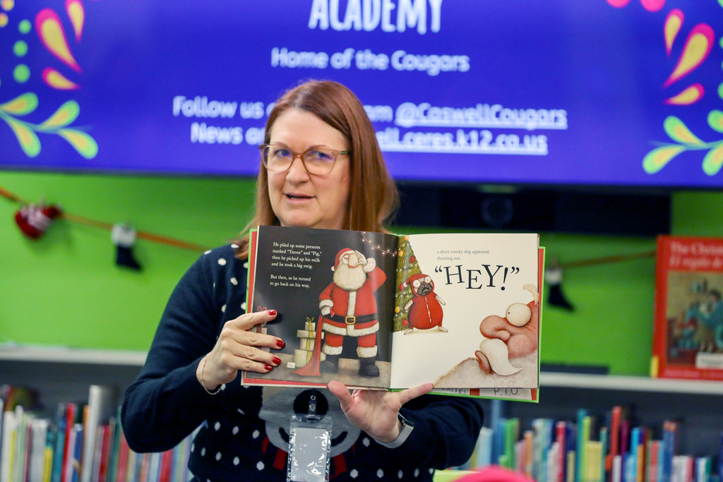 Superintendent, reading book to class, holds up illustrations