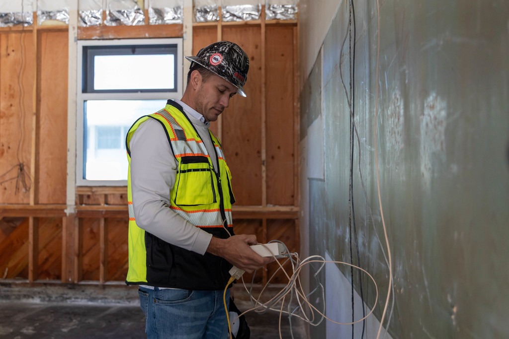 Construction worker inspecting wires