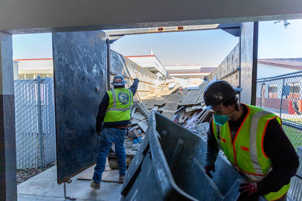 construction workers throwing away trash