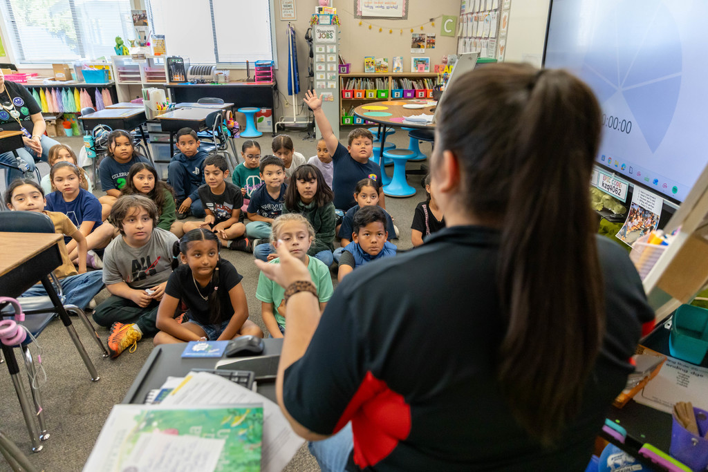 a woman talking to a classroom full of students