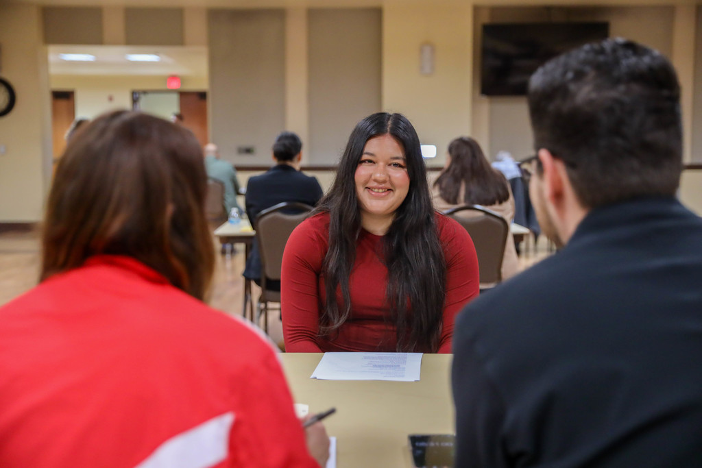 Student interviewing at a table