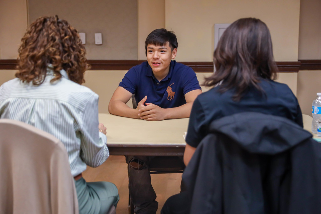 Student interviewing at a table
