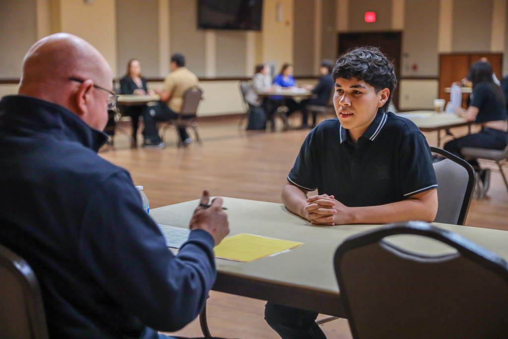 Student interviewing at a table