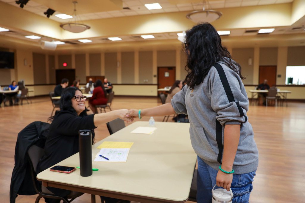 Adult and student shaking hands