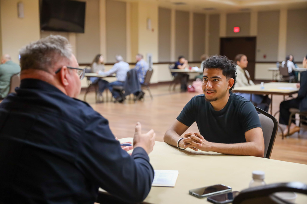 Student interviewing at a table