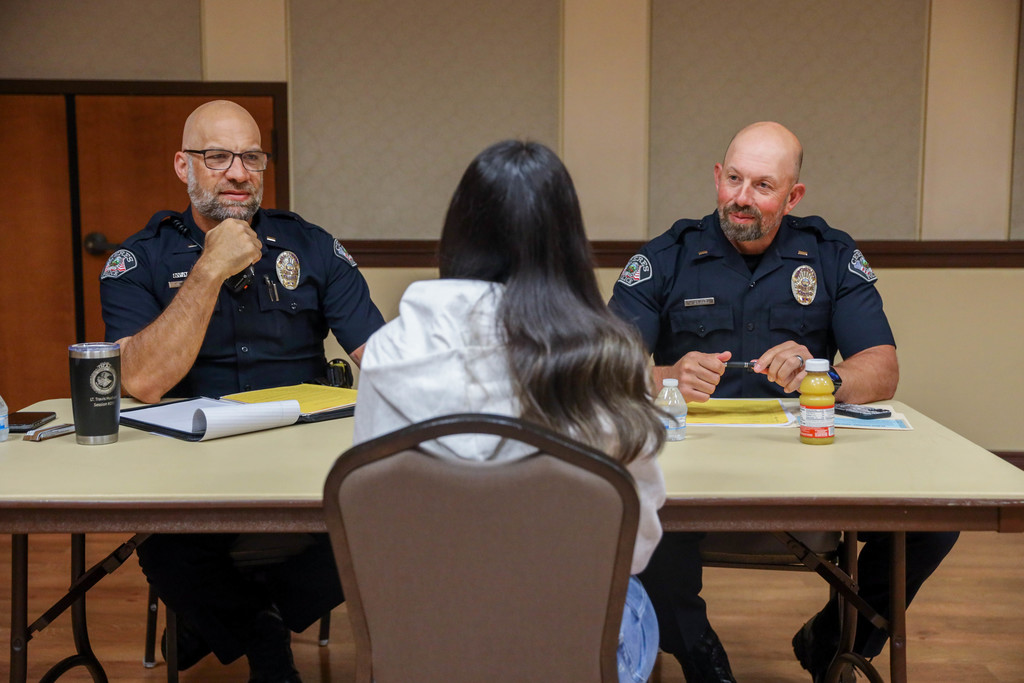 Police officers interviewing students at a table
