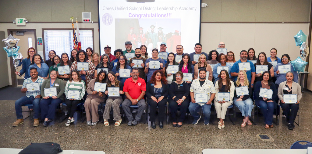 Group photo of Leadership Academy graduates holding certificates