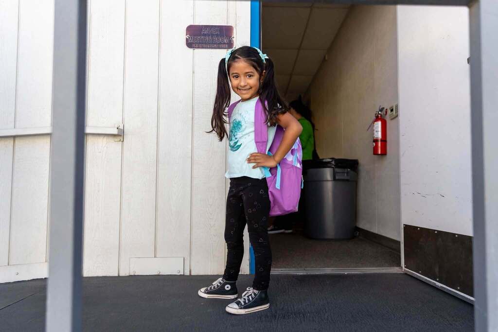 Little girl showing off new backpack