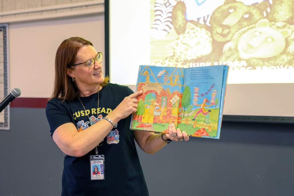 Dr. Peterman pointing to a page in a book she is holding