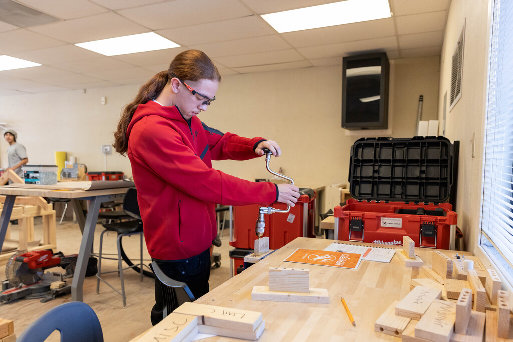 Student using a hand drill