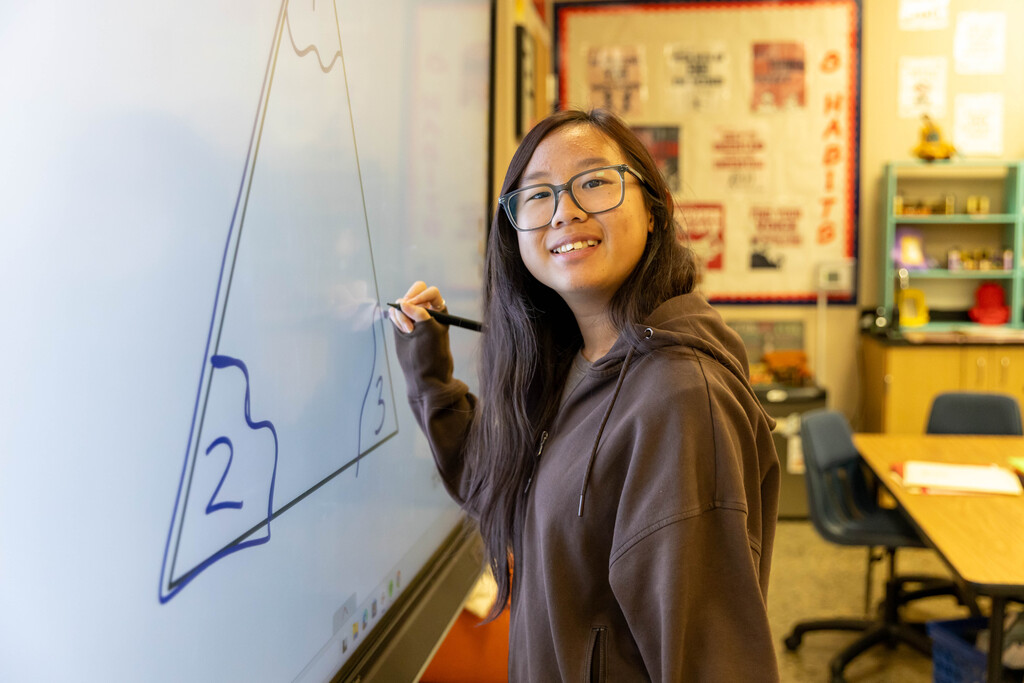 student working on a white board