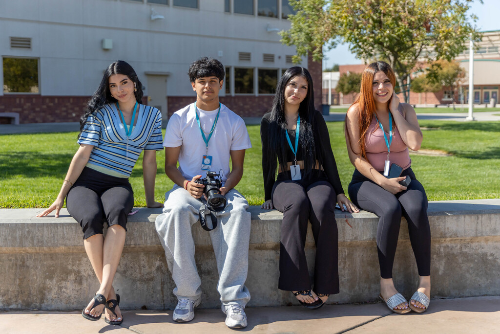 four students sitting in the quad