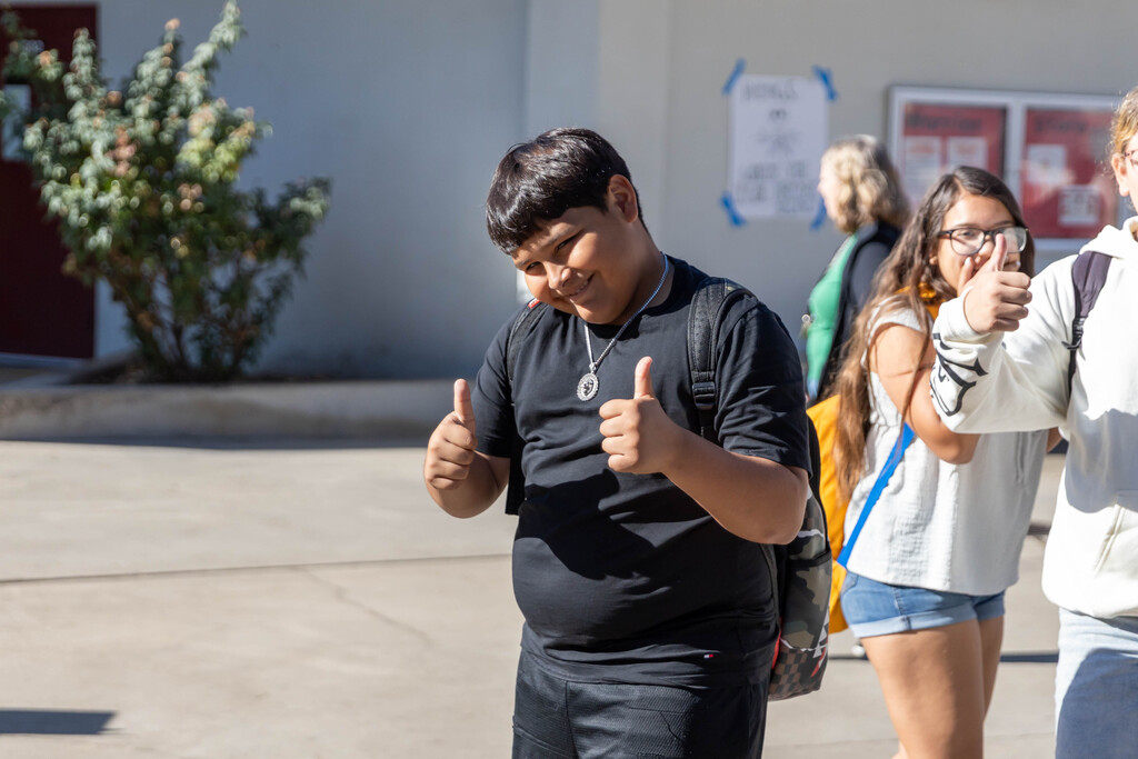 Smiling student gives double thumbs-up