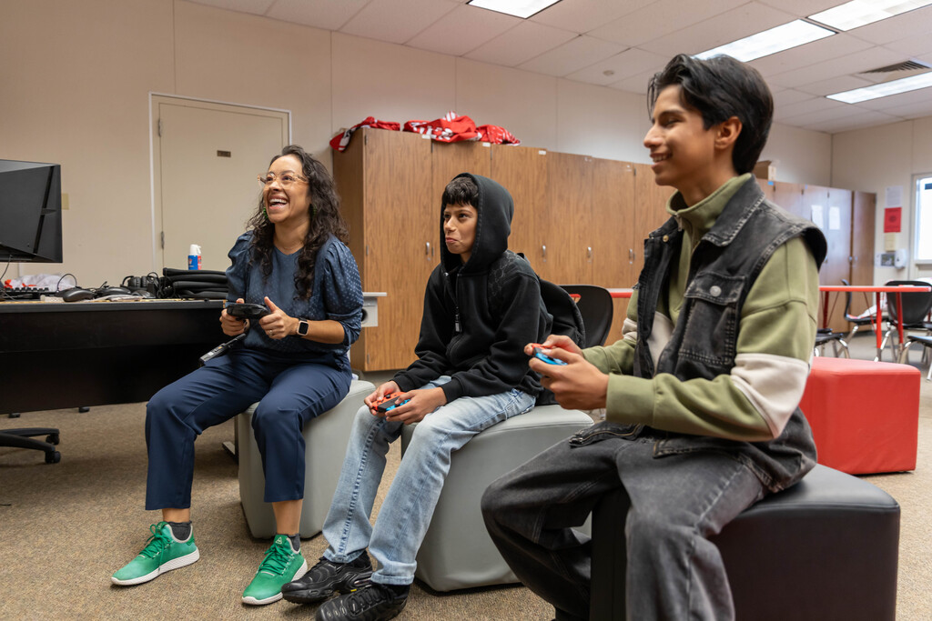 Principal and two students with game controllers