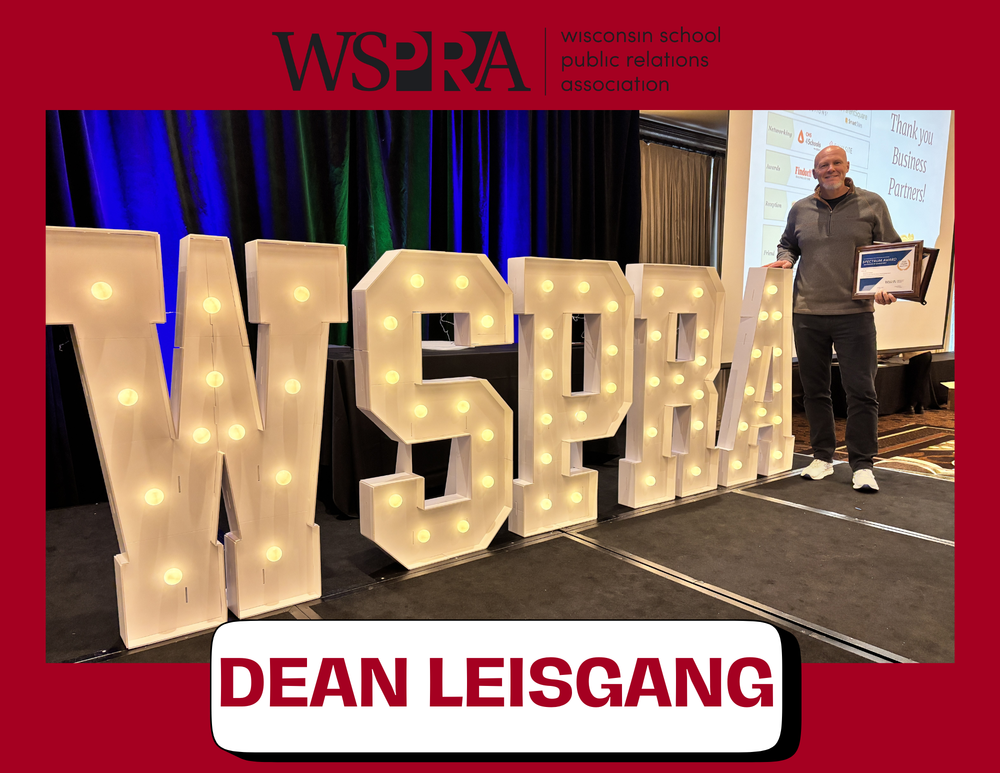 Dean Leisgang posing with awards in front of a WSPRA sign.