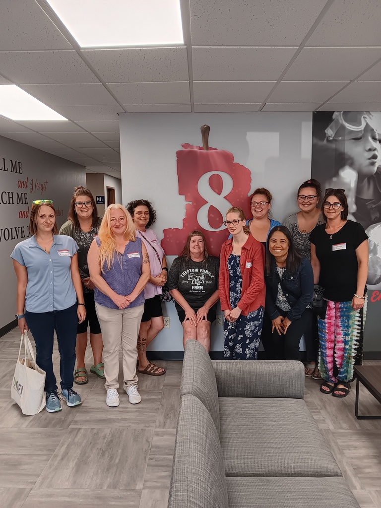 Small group posing in front of CESA 8 logo.