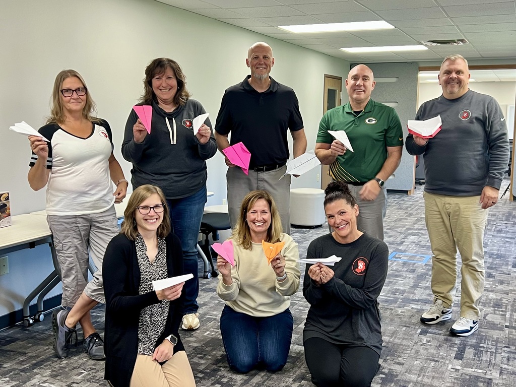 Staff posing with paper airplanes.