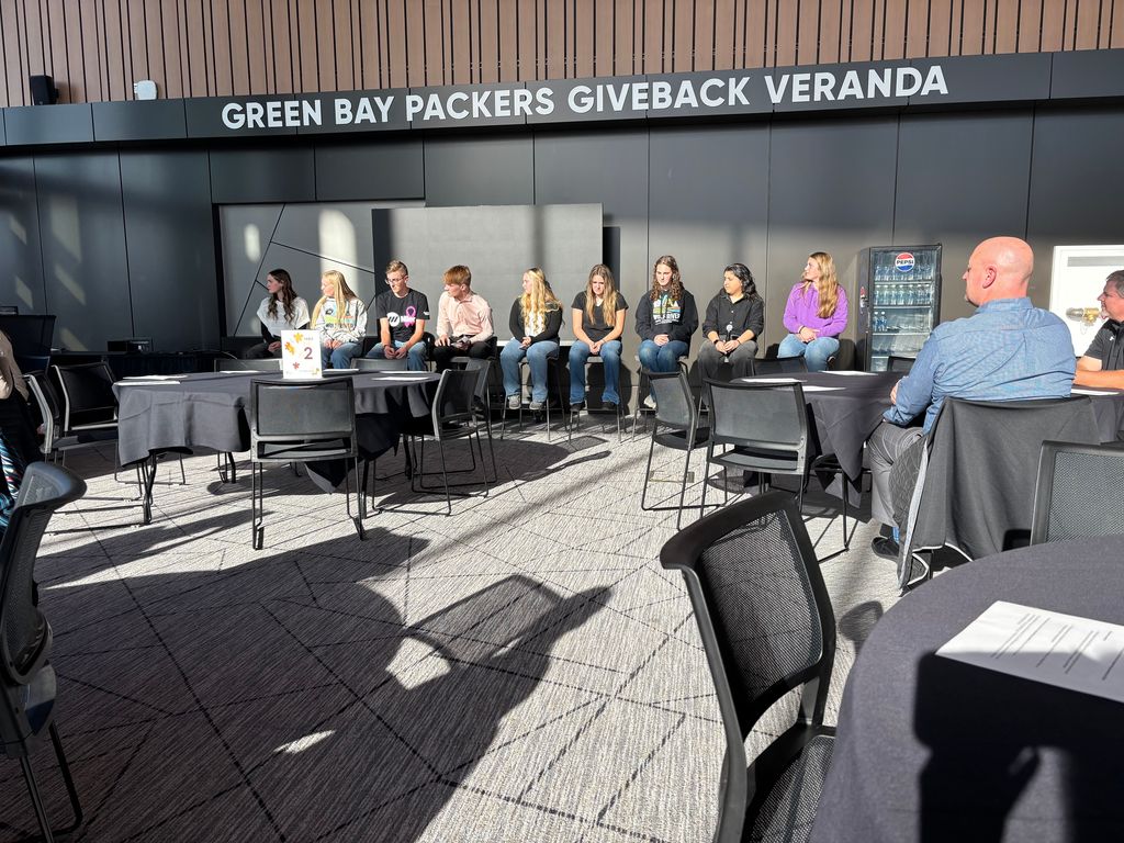 YA students speaking on a panel at Lambeau Field.