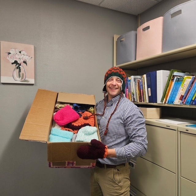 A box of winter hats donated to a school district.