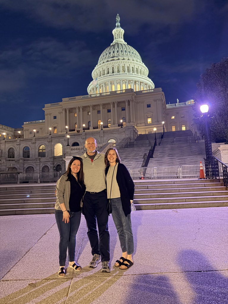 Jenny, Dean, and Aly at an AI Policy Summit standing in front of the Capital in Washington D.C.