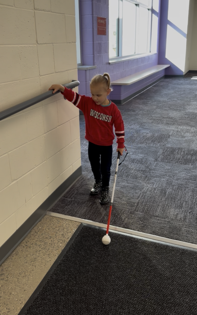 A visually impaired student walking with a cane.