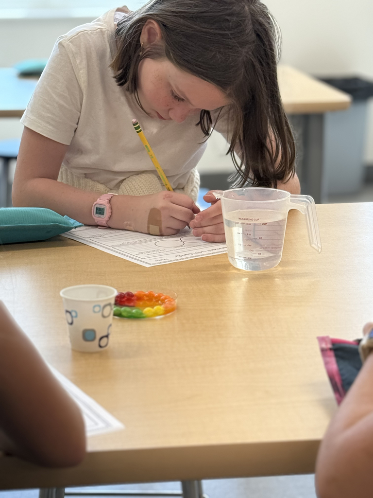4th grade scientists observe and record skittles interacting with water in the CFIS Science lab.