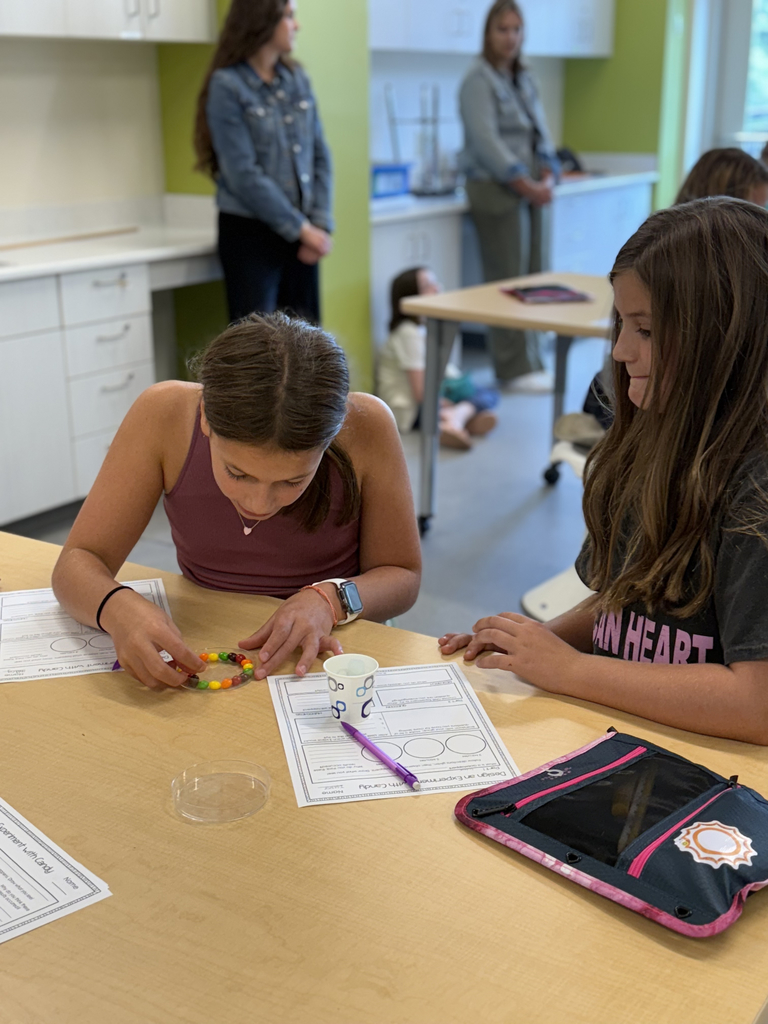 4th grade scientists observe and record skittles interacting with water in the CFIS Science lab.