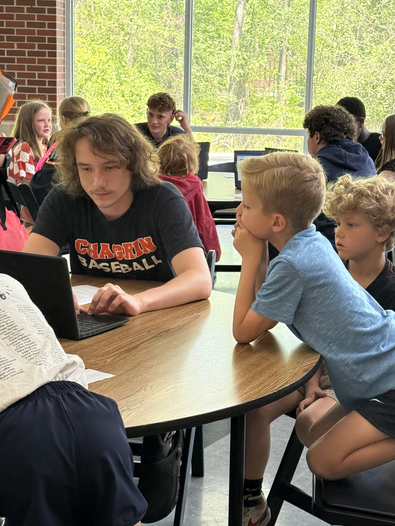2nd grade students working with HS students to create poster for their mini-society projects.