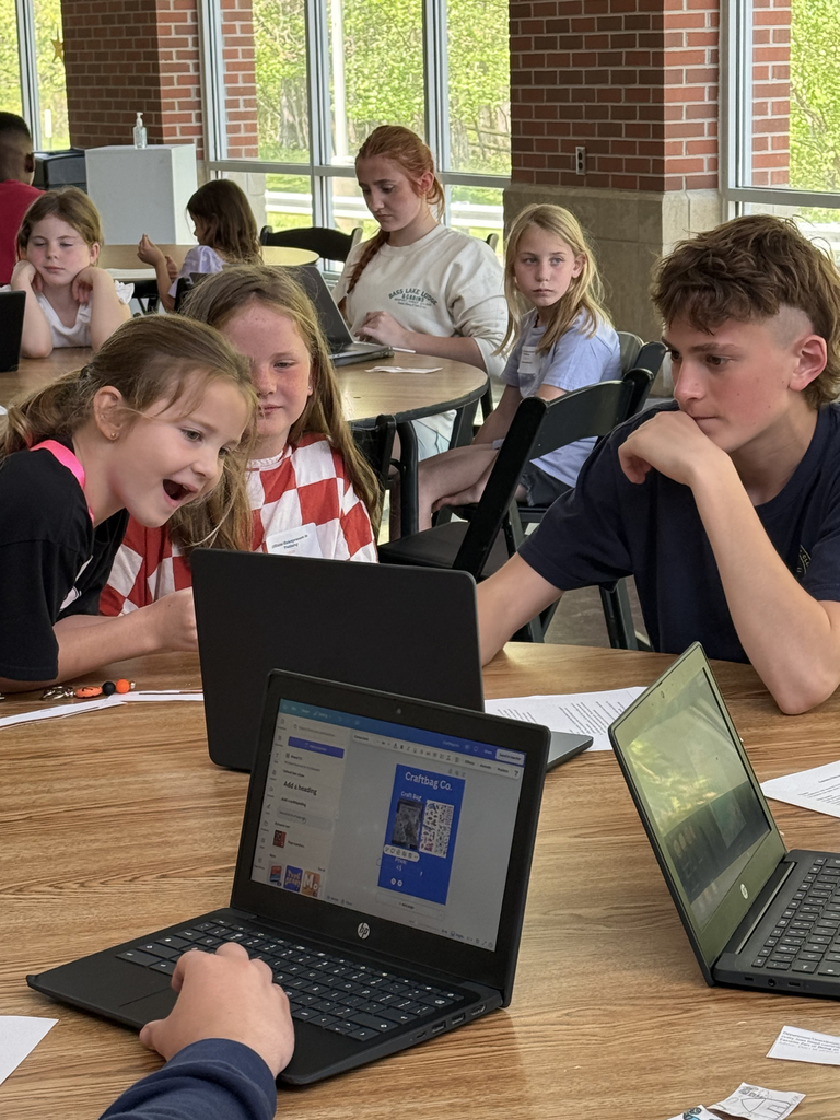 2nd grade students working with HS students to create poster for their mini-society projects.