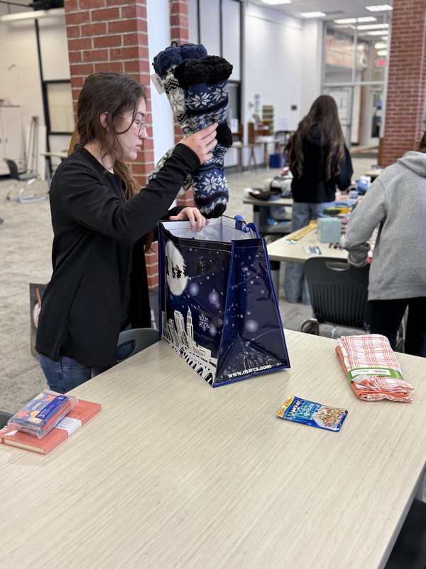 Students working together to assemble bags to give to those in need.