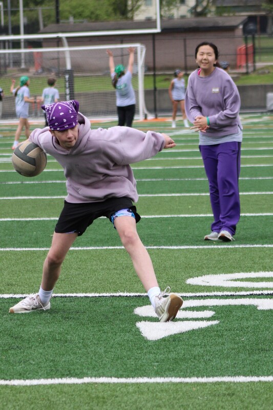 8th grade kick it for cancer game, students cheering eachother on and playing kickball
