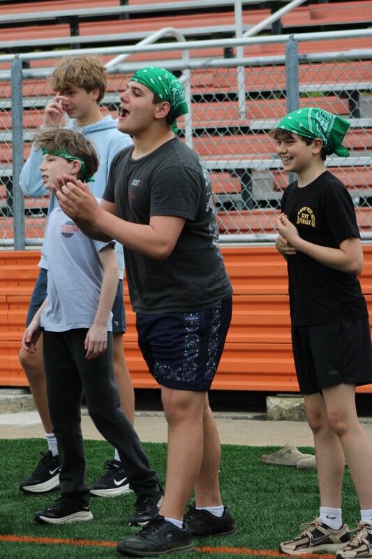 8th grade kick it for cancer game, students cheering eachother on and playing kickball