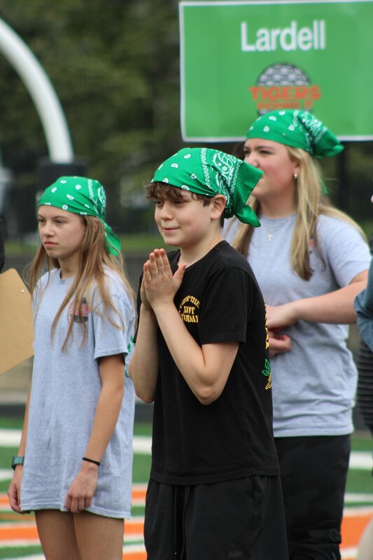 8th grade kick it for cancer game, students cheering eachother on and playing kickball