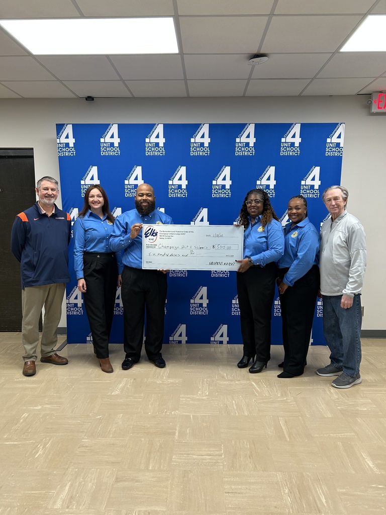 Elks Lodge donating $500 to Kids Plus in front of a step and repeat Unit 4 banner.