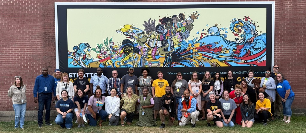 Stratton staff in front of a colorful mural.