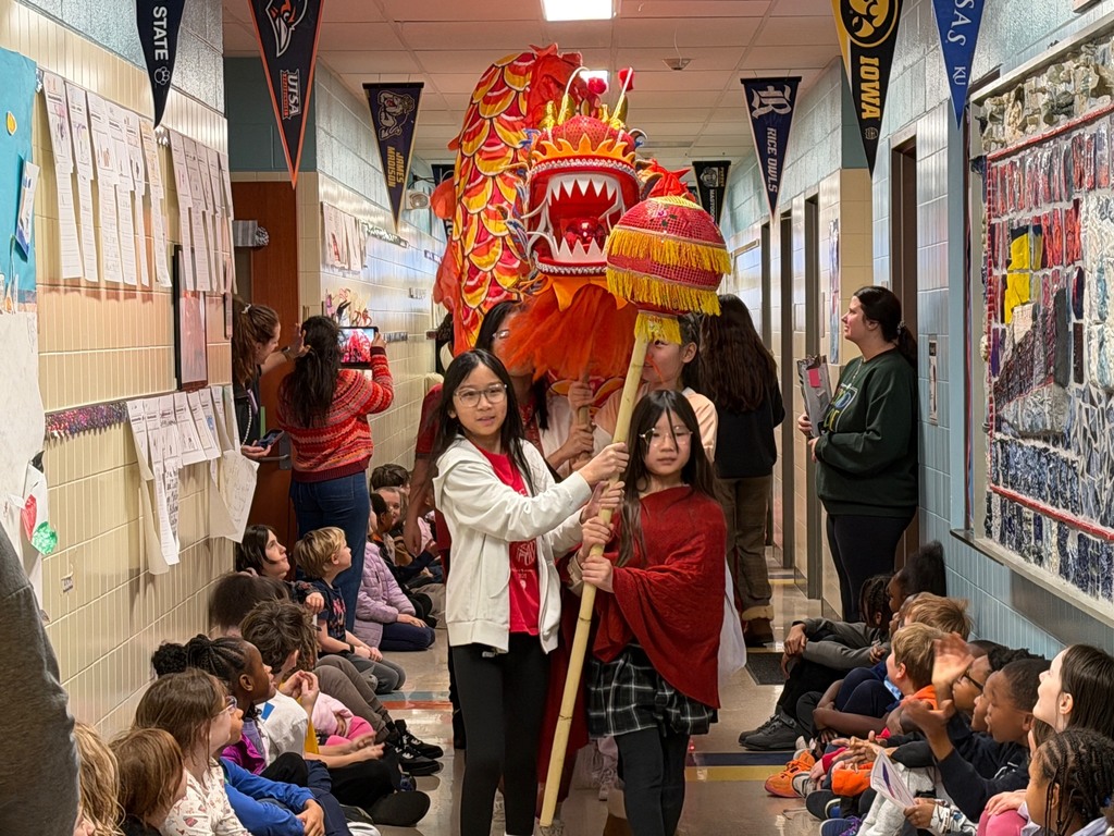 Students watching the Lunar New Year Parade as student carry their red dragon