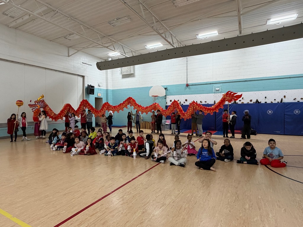 Student sitting in front of their red dragon prior to their parade