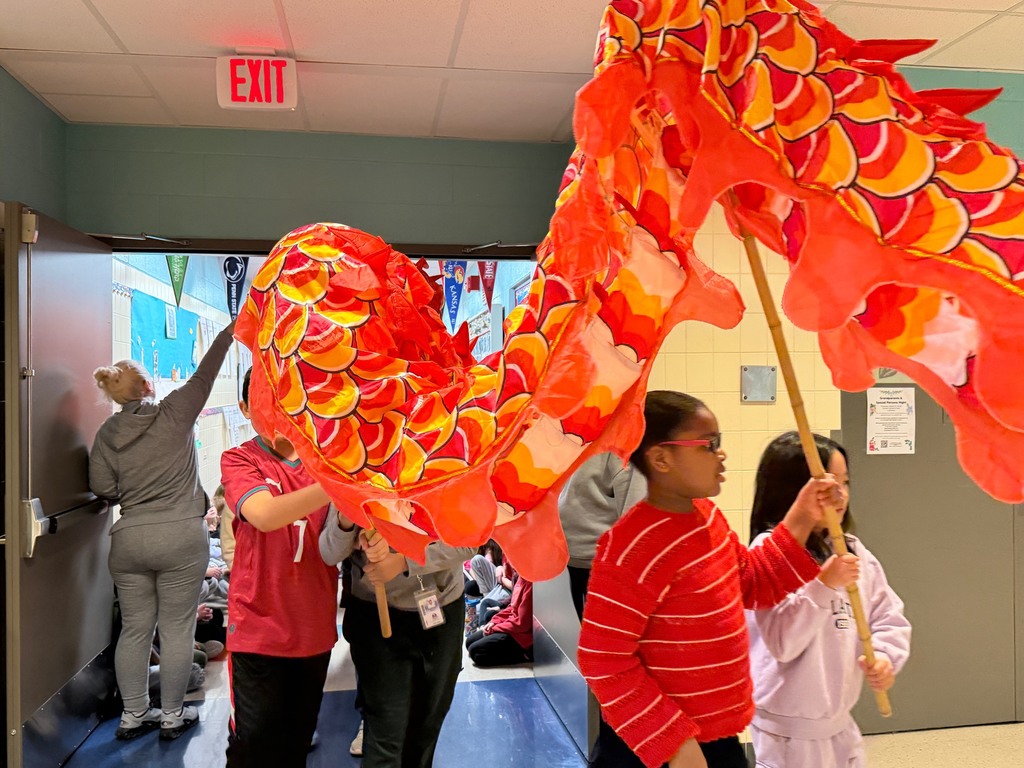 Students watching the Lunar New Year Parade as student carry their red dragon