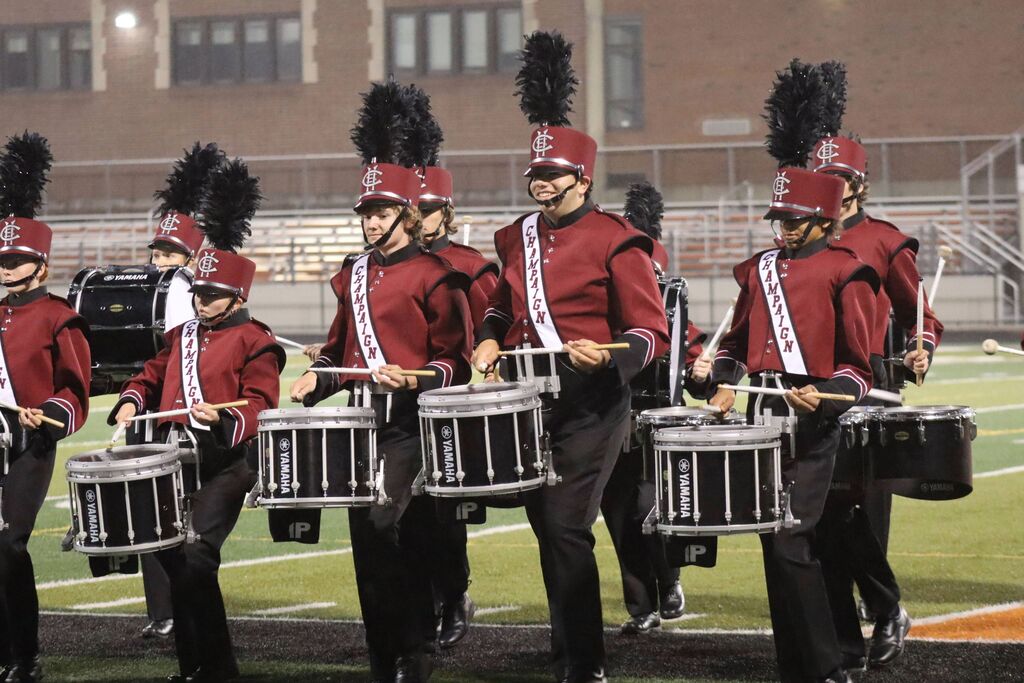 Champaign Central High School marching band students play drumline instruments.
