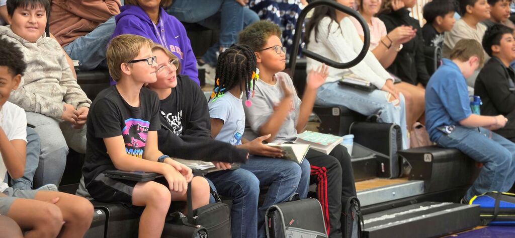 Students listen to an author reading a book at International Prep Academy.
